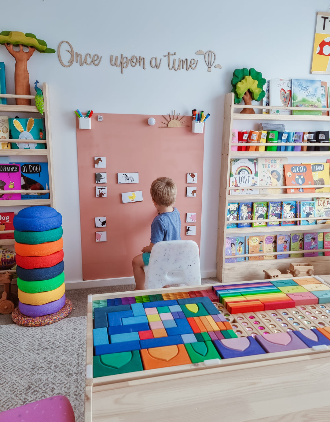 Child practicing alphabet letters on a Maynetic board in a playroom